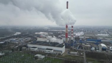 Kasabaya ısı ve elektrik üreten termik santralin hava görüntüsü. Duman emisyonları ve endüstriyel yapılar. Kış mevsiminde şehir evlerini ısıtma işlemi. Emisyon azaltma ve ekoloji