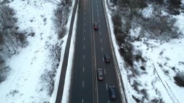 Karla kaplı bir yolda seyahat eden araçların hava görüntüsü dinamik hareketler ve değişen manzaralar sergiliyor. Yavaş yavaş uzaklaşıp geniş kış manzarasını gözler önüne seriyor.