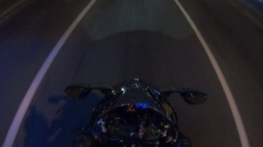 Motosikletli güçlü bir sürücü loş şehir sokaklarında gece boyunca gölgeler ve yansımalarla dolu kentsel bir ortamda hız ve maceranın heyecanını gözler önüne seriyor..