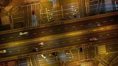 Gece dinamik trafik akışıyla hareketli şehir kavşağında hava zaman atlaması. Şehir akşam manzarası. Modern şehrin yaşam tarzı ve ritmi. Arabalar ve toplu taşıma için uygun bir kavşak