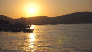 Gün batımında sahil duran balıkçı tekneleri siluetleri. Güzel akşam dalgalar üzerinde sallanan balıkçı gemileri. Doğa arka plan. Güzel manzara. Ağır çekim.