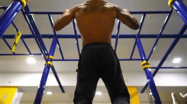 Modern spor salonunda barfiks çeken kaslı Afro-Amerikan sporcu. Genç Afrikalı sporcu yatay barda egzersiz yapıyor. Spor kulübünde güçlü bir sporcu eğitimi. Sağlıklı ve aktif yaşam tarzı kavramı.