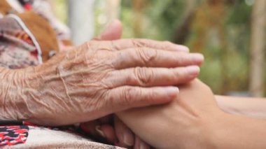 Dışarıda genç bayanların kollarını okşayan yaşlı kadınların eli. Torunumla büyükannem dışarıda vakit geçiriyorlar. İlgi ve sevgi kavramı. Yan Görünümü Kapat Yavaş Çekim.