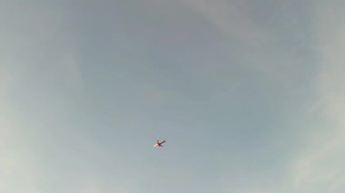 Renkli günbatımı gökyüzünde uçan yolcu uçağı havaalanına doğru iniyor ve aşağıdaki şehri gösteriyor. Uçak yere inmeden önce zarifçe iniyor. Turizm gezisi ve hava yolculuğu kavramı