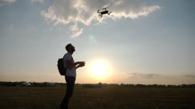 Pilot, insansız hava aracını ustalıkla günbatımına fırlatıyor. Uçuşun heyecanını ve teknolojinin güzelliğini büyüleyici doğal bir arka plana yansıtıyor.