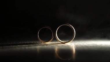 Alyanslar yumuşak ışıkta parıldıyor, karmaşık ayrıntıları ve yansımaları vurguluyor, aşkı ve bağlılığı güzel sahnelenmiş bir sahnede sembolize ediyor