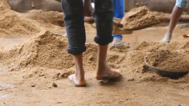 İnşaat alanındaki kil çömleklere kürekle kum döken tanınmamış Hintli adamlara yakın durun. İnşaat alanında çalışan yerel inşaatçılar. Gelecekteki proje kavramı.