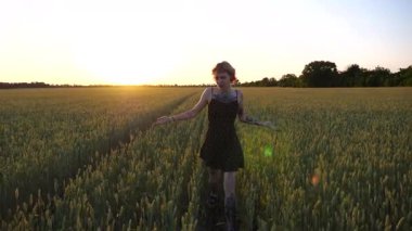 Kısa siyah elbiseli neşeli punk kızı buğday çayırlarında dolaşırken aylaklık ediyor. Dövmeli mutlu bayan hippi gün batımında yeşil arpa tarlasından geçiyor. Özgürlük kavramı.