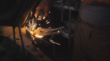 Tamircinin ya da tamircinin erkek eli atölyedeki kaynak makinesini kullanarak eski arabanın metal parçalarını kaynaklıyor. Karanlıkta garajda kaynak yaparken yanıp sönen ışıklar ve kıvılcımlar. Yan Görünüm Yavaşça Kapat.