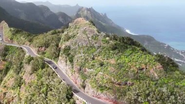 Bereketli yeşillik ve okyanus dalgalarıyla kayalık uçurumlar boyunca uzanan sarmal kıyı yolunun hava manzarası, dağlık bir bölgenin çarpıcı manzarasını gözler önüne seriyor.