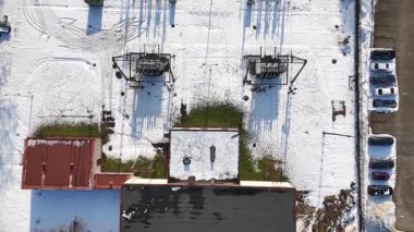 Karla kaplı zemini olan elektrik santralinin hava görüntüsü, elektrik hatlarını, trafoları ve yapıları gösteriyor. Civardaki ekipman ve binaların oluşturduğu gölgeler de var.