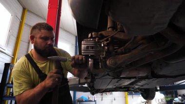 İyi donanımlı bir garajda detaylı tamirat yapan yetenekli otomotiv teknisyeni, karmaşık araba bakım ve mekanik uzmanlık sürecini gözler önüne seriyor..