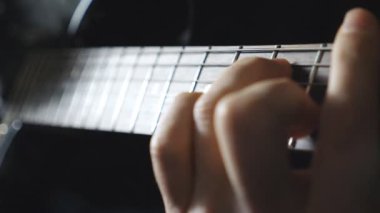 Elektro gitaristin kollarını kapatın. İpleri tıngırdatan gitaristin erkek parmakları. Rock müzik solosu yapan adamın elleri. Yetişkin adam müzik aleti çalıyor. Dolly vurdu..