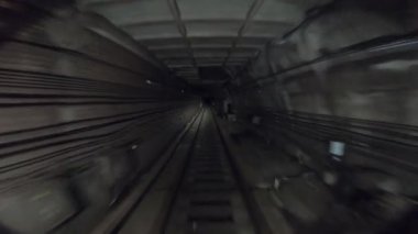 Yeraltı treni karanlık tünelde ilerliyor. Şehir metrosu yerin altında. Metro treni karanlık tünelden hareket ediyor. Demiryolu kulübesinden bakış açısı. İnsan taşımacılığı kavramı. Yavaş çekim.