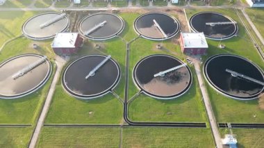 Su arıtma tesisinin havadan görüntüsü dairesel tanklar ve makineler gösteriyor. Etrafı yeşilliklerle çevrili kanalizasyon sistemi. Büyük şehrin modern endüstriyel fabrikası. Ekoloji dostu fabrika