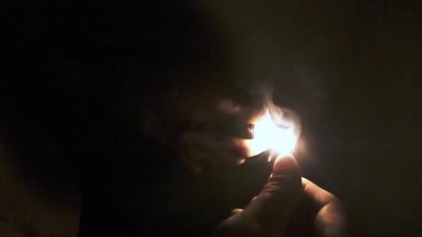 Homem acende um fósforo na escuridão e queima em fundo preto. câmara lenta — Vídeo de Stock