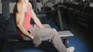 Spor salonunda egzersiz yapan erkek dumbbells ile eller