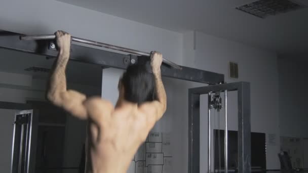 Hombre haciendo un músculo en el gimnasio — Vídeo de stock