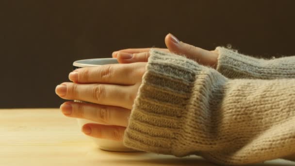 Kvinna med fika, uppvärmningen hennes händer. Mens armar runt kvinnans händer — Stockvideo