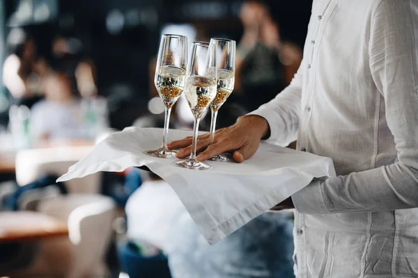 Primer plano de copas con un delicioso champán fresco, camarero con champán en una bandeja —  Fotos de Stock