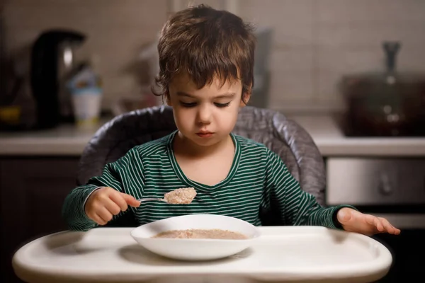 Маленький мальчик с аутизмом ест кашу — стоковое фото