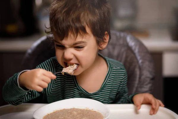 Маленький хлопчик з аутизмом їсть кашу Стокове Зображення