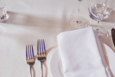 Masa örtüsü, çiçek çatalı, restoranda servis edilen ve içi rahat olan bıçak.