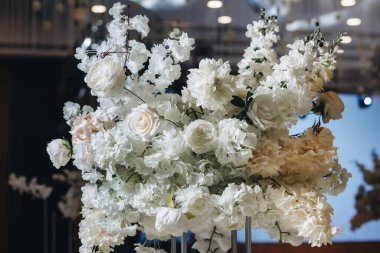 Beyaz güller, ranunculus, İran düğün çiçekleri, beyaz orkideler ve mumlar içeren geniş çiçek buketleri içeren romantik düğün masası süslemesi.