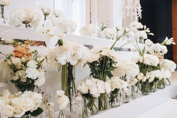 Романтический свадебный стол Верхняя композиция Декор с большими пышными цветочными букетами, включая белые розы, ranunculus, персидские лютики, белые орхидеи и свечи