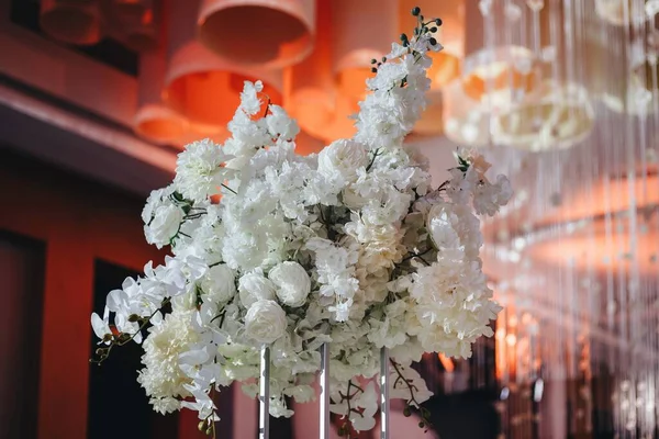 Decoração de layout de mesa de casamento romântico com grandes buquês florais exuberantes, incluindo rosas brancas, ranúnculo, buttercups persas, orquídeas brancas e velas — Fotografia de Stock