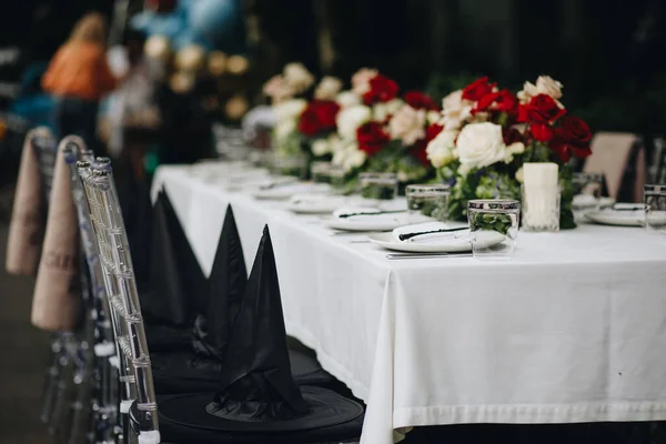 Stolní nádobí brýle, květinová vidlička, nůž sloužící k večeři v restauraci s útulným interiérem — Stock fotografie