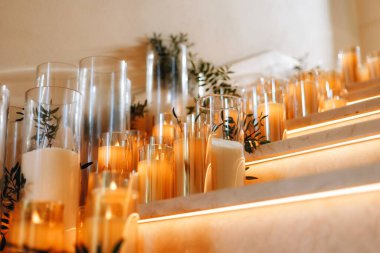 Beyaz güller, ranunculus, İran düğün çiçekleri, beyaz orkideler ve mumlar içeren geniş çiçek buketleri içeren romantik düğün masası süslemesi.