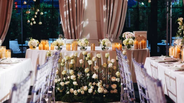 Decoração de layout de mesa de casamento romântico com grandes buquês florais exuberantes, incluindo rosas brancas, ranúnculo, buttercups persas, orquídeas brancas e velas — Fotografia de Stock