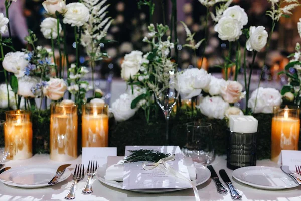 Romantic Wedding Table Top Layout Decor with large lush floral bouquets including white roses, ranunculus, persian buttercups, white orchids and candles — Stock Photo, Image