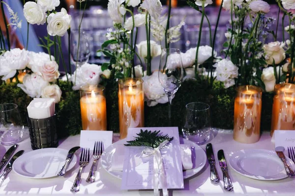 Decoração de layout de mesa de casamento romântico com grandes buquês florais exuberantes, incluindo rosas brancas, ranúnculo, buttercups persas, orquídeas brancas e velas — Fotografia de Stock