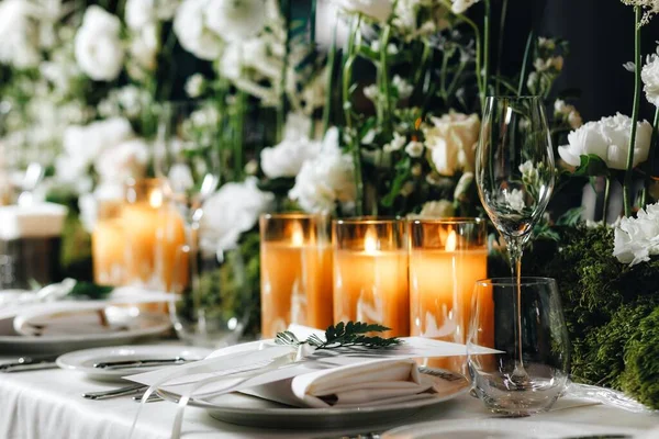 Romantic Wedding Table Top Layout Decor with large lush floral bouquets including white roses, ranunculus, persian buttercups, white orchids and candles — Stock Photo, Image