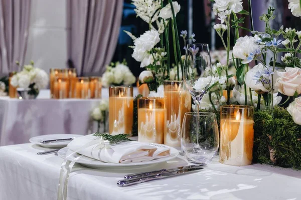 Romantic Wedding Table Top Layout Decor with large lush floral bouquets including white roses, ranunculus, persian buttercups, white orchids and candles — Stock Photo, Image