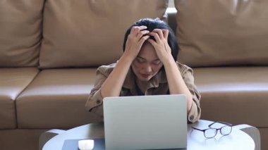 Evde dizüstü bilgisayarla çalışan Asyalı iş kadını iş, iş, ev ve çalışma alanlarından stres hissediyor