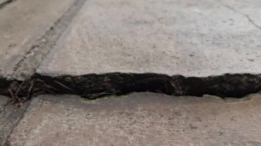 Çimento desenli beton zemin manzarası, bir evin zemininde ya da bir depremin yol açtığı sokak yolunda ciddi hasar ve çöküntü olduğunu gösteriyor.