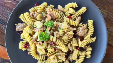 Makarna. Acı biber, sarımsak, zeytinyağı, Fusilli İtalyan sosisi, ahşap bir masada hafif baharatlı bir tat. İtalyan yemeklerinin en üst görüntüsü