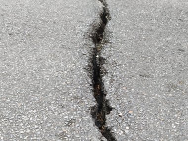 Çatlamış uzun ve geniş asfalt yolun yakın görüntüsü. arkaplan için beton duvar dokusu.