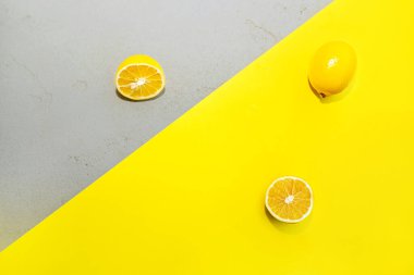 Sarı ve gri beton arka planda sarı limonlu kompozisyon.