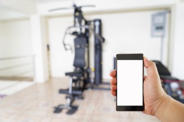 El ile Fitness Spor salonu Merkezi Mevsimlik arka plan üstünde hareket eden telefon