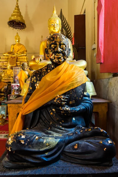 Sitzende schwarze Buddha-Statue mit Blattgold — Stockfoto