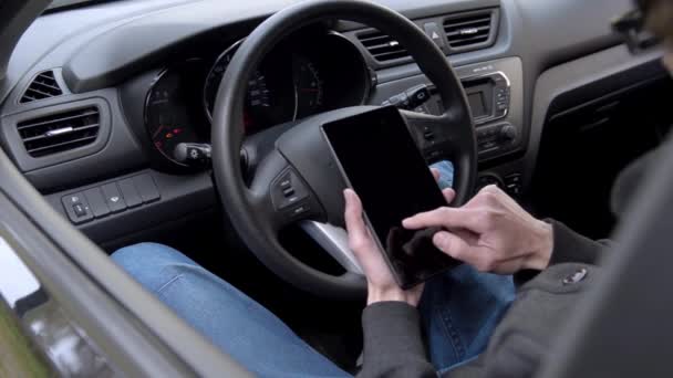 Homem usa tablet no carro — Vídeo de Stock