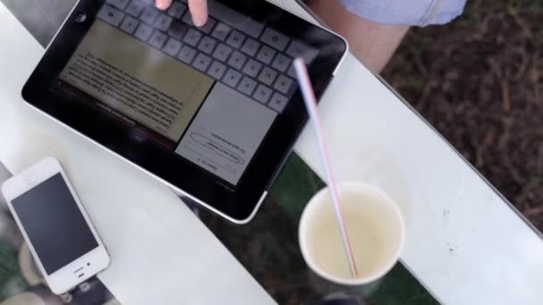Man te typen op een tablet in het park — Stockvideo