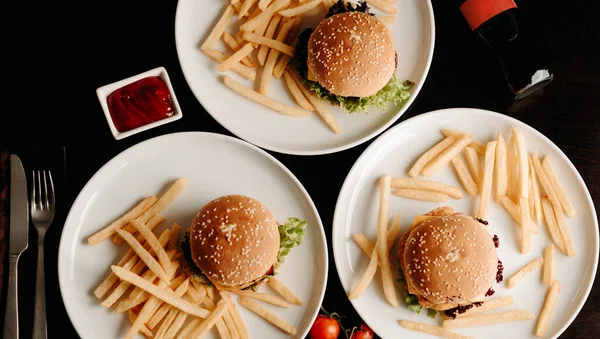 黒テーブルの上の3つの異なるハンバーガー — ストック写真