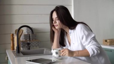 Sabahları kız mutfakta kahve içer.