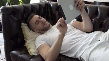 Adam evdeki tablette daktilo yazıyor.