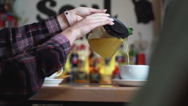 女人的手从玻璃瓶里倒茶到杯子里 茶时间 — 图库视频影像